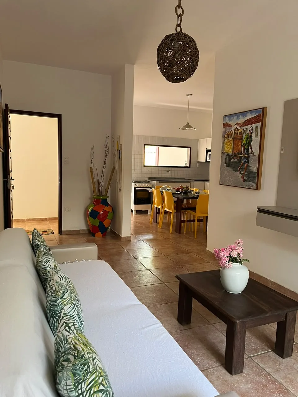Sala de estar com sofá, mesa de centro e cozinha ao fundo